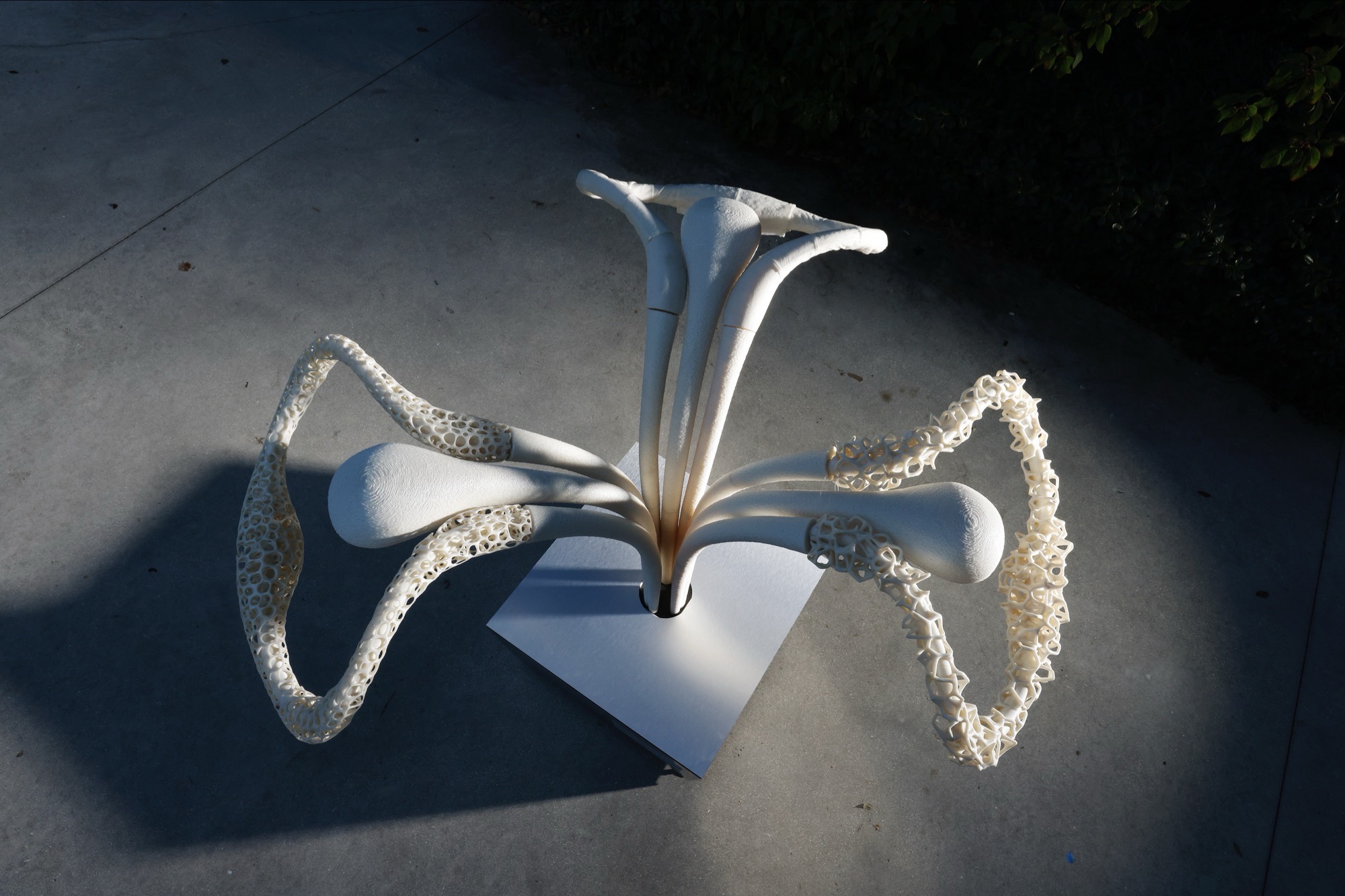 A visitor's hand interacting with the scultpure, which is glwing. The Car model in the Background.