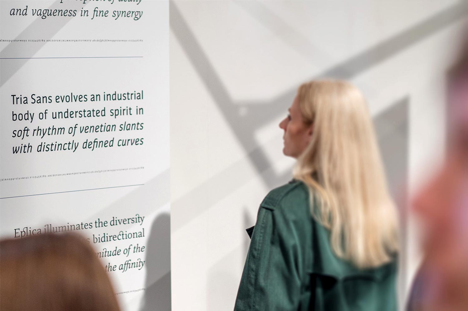 A woman watching a poster showing typography